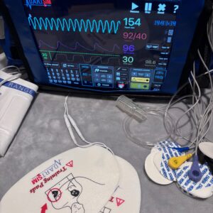 Heart monitor displaying vital signs above pediatric medical equipment.